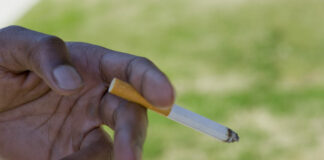 Ruka držící zapálenou cigaretu – ilustrační fotografie