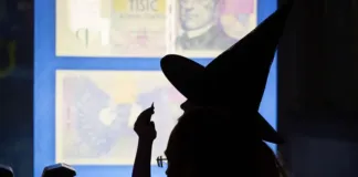 Symbolické zobrazení trezoru a zlatých mincí ve tmě